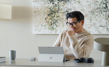 Person sitting at a desk looking at a tablet